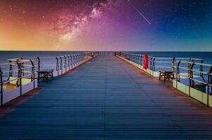Landscape with Milky way galaxy and Sunset over pier at Saltburn by the Sea, North Yorkshire, UK. photo