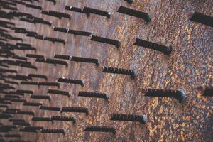 An abstraction of rusty iron bars cut short and occluded with large iron plates. photo