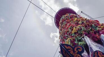 Salak yom at Wat Phra That Hariphunchai in Lamphun. The tradition of making merit, the tall dyed lott trees are decorated with different colored paper and clothing items to pay homage to the souls. photo