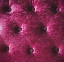 The back of the sofa chair is made of pink velvet fabric. photo