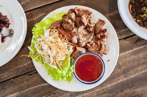 Pork intestines are battered and fried, placed in tomato sauce and shredded vegetables. photo