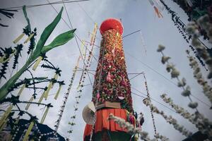 Salak yom at Wat Phra That Hariphunchai in Lamphun. The tradition of making merit, the tall dyed lott trees are decorated with different colored paper and clothing items to pay homage to the souls. photo