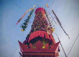 Salak yom at Wat Phra That Hariphunchai in Lamphun. The tradition of making merit, the tall dyed lott trees are decorated with different colored paper and clothing items to pay homage to the souls. photo