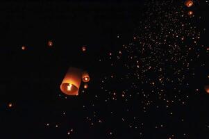 The beauty of the lanterns floating in the sky during the Yi Peng Festival and the Floating Lantern Festival in Chiang Mai Province, Thailand. photo