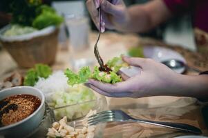 Nam Nueng, a Vietnamese dish, is a dish consisting of vegetable dough, salad, raw bananas, chili, garlic, and pork, then topped with a sweet dipping sauce. photo