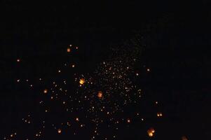 The beauty of the lanterns floating in the sky during the Yi Peng Festival and the Floating Lantern Festival in Chiang Mai Province, Thailand. photo