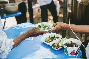 manos de hambriento personas preguntando para gratis comida desde voluntarios humanitario ayuda concepto foto