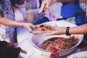 manos de hambriento personas preguntando para gratis comida desde voluntarios humanitario ayuda concepto foto