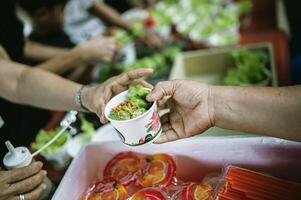 manos de el pobre recibir comida desde el del donante compartir. pobreza concepto foto