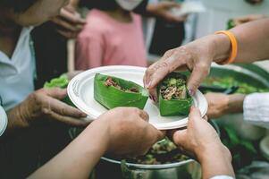 Volunteers offer free food to the poor. the concept of food sharing. photo