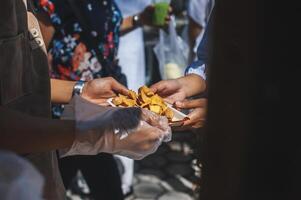 voluntarios dar comida a el pobre, compartir gratis comida a ayuda mendigos comida donación concepto foto