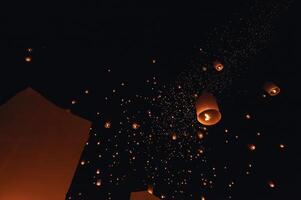 The beauty of the lanterns floating in the sky during the Yi Peng Festival and the Floating Lantern Festival in Chiang Mai Province, Thailand. photo