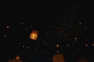 The beauty of the lanterns floating in the sky during the Yi Peng Festival and the Floating Lantern Festival in Chiang Mai Province, Thailand. photo