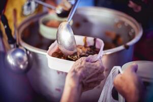 The hands of the poor apply for food from rich people who donate food. photo