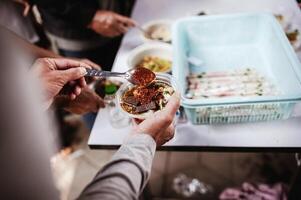 manos de el pobre recibir comida desde el del donante compartir. pobreza concepto foto