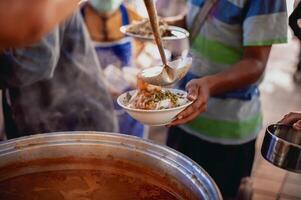 Giving food to beggars to help reduce hunger with concern. Concepts of food donations and aid photo