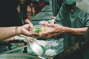 The hands of beggars receive donated food. concept of charity food for the poor photo