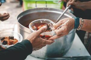 voluntarios son Ayudar a dar gratis comida a el hambriento sin hogar. comida Servicio y comida donación concepto foto