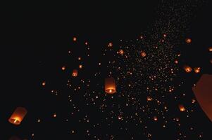 The beauty of the lanterns floating in the sky during the Yi Peng Festival and the Floating Lantern Festival in Chiang Mai Province, Thailand. photo