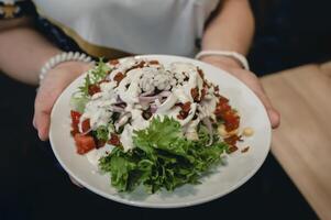 Person holding a plate of healthy food menu with fruits and vegetables. photo