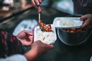 The hands of beggars receive donated food. concept of charity food for the poor photo