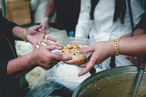 el manos de mendigos recibir donado alimento. concepto de caridad comida para el pobre foto