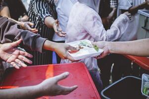 el manos de mendigos recibir donado alimento. concepto de caridad comida para el pobre foto