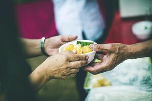 The hands of beggars receive donated food. concept of charity food for the poor photo