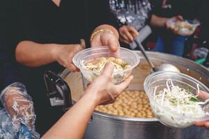 dando comida a mendigos a ayuda reducir hambre con inquietud. conceptos de comida donaciones y ayuda foto