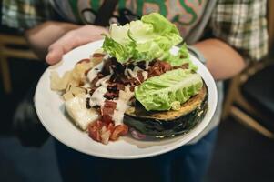 Person holding a plate of healthy food menu with fruits and vegetables. photo