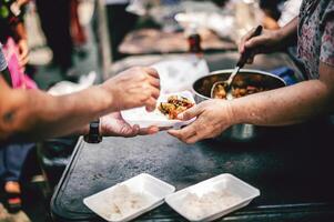 The hands of beggars receive donated food. concept of charity food for the poor photo