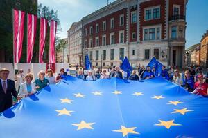 alegre celebracion con UE y letón banderas en antiguo pueblo de riga. foto