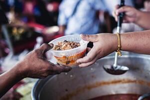 concepto de caridad comida para el pobre. el concepto de vida problemas, hambre en sociedad . Ayudar personas con hambre con amabilidad . el manos de mendigos recibir donado comida foto