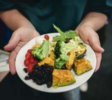 persona participación un plato de sano comida menú con frutas y vegetales. foto