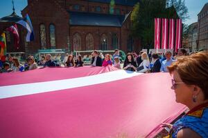 vibrante celebracion en riga antiguo ciudad, letones sostener bandera foto