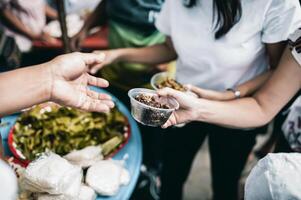 concept of charity food for the poor . the concept of life problems, hunger in society . Helping People With Hunger With Kindness. The hands of beggars receive donated food photo