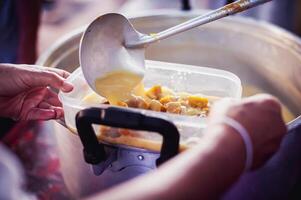 caridad alimento, comida para el pobre hambriento voluntarios ofrecimiento comida a ayuda el Vagabundo el idea de consiguiendo ayuda desde compañero humanos foto