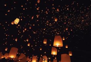 The beauty of the lanterns floating in the sky during the Yi Peng Festival and the Floating Lantern Festival in Chiang Mai Province, Thailand. photo