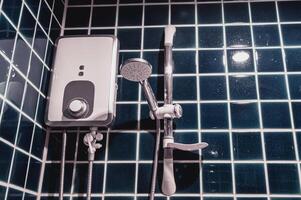 ducha con eléctrico agua calentador montado en un azul pared en un lujoso baño. foto