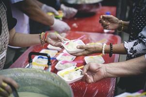 voluntarios son Ayudar a dar gratis comida a el hambriento sin hogar. comida Servicio y comida donación concepto foto