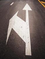 A sign on the road showing that there is a left turn at the intersection. photo