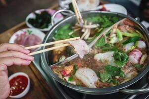 Hot pot with clear soup, Pork, fish, vegetables, blanched in hot broth and dipped in a variety of sauces. photo