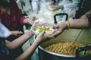 voluntarios son Ayudar a dar gratis comida a el hambriento sin hogar. comida Servicio y comida donación concepto foto