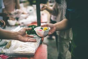 Ayudar donar gratis comida a llenar el estómagos de el pobre el concepto de inanición y hambre problemas. foto