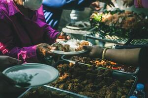 Volunteers serving hot meals to hungry migrants humanitarian aid concept. photo