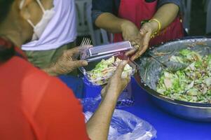 Feeding concept Homeless people offer free food from outdoor volunteers. photo