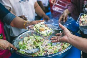 Volunteers offer free food to the poor. the concept of food sharing. photo