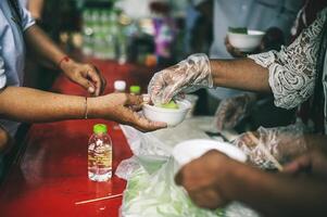 Feeding concept Homeless people offer free food from outdoor volunteers. photo