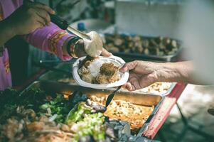 Volunteers give food to the poor, share free food to help beggars. food donation concept photo