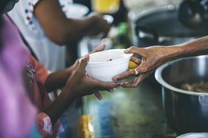 Hungry homeless people request free food donations from volunteers social concept of helping photo